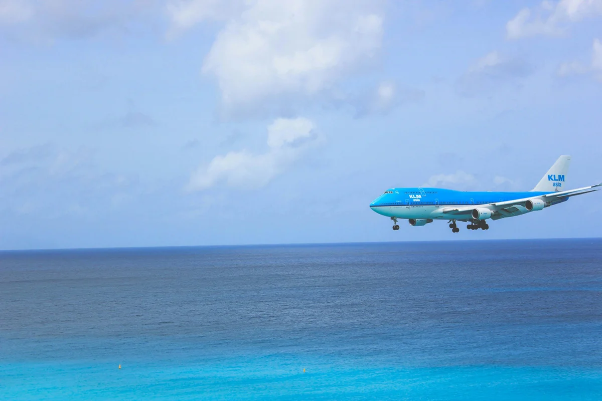 a Boeing 747-8 passenger jet flying through a clear blue sky